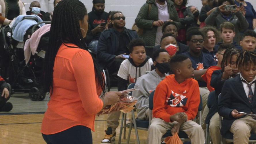 Teacher distributes bow tie awards at W.E.B. DuBois Academy
