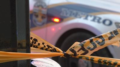 Crime scene tape near LMPD cruiser