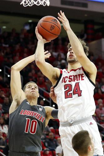 North Carolina State's Devon Daniels (24) drives the ball past Louisville's Samuell Williamson