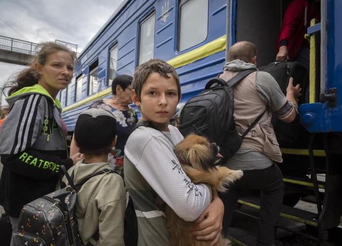 A boy holds his pet dog as his family evacuated.jpeg
