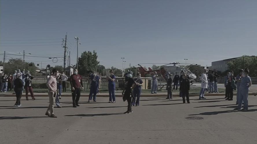 Health care workers look up at flyover