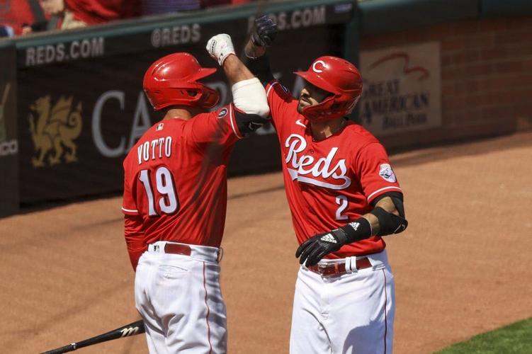 Cincinnati Reds' Joey Votto, left, celebrates the three-run home run by Nick Castellanos