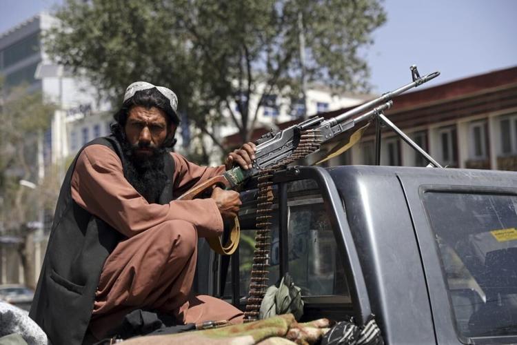 Taliban fighter on back of pickup truck with gun
