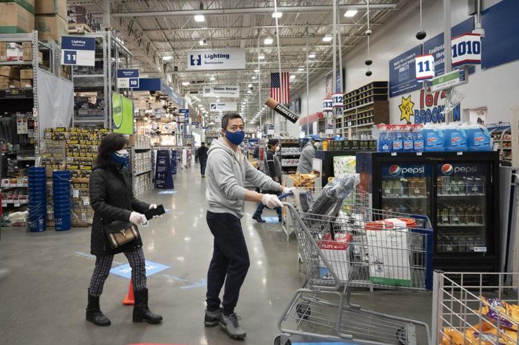 Lowe's customers in New York wear gloves and masks as they shop