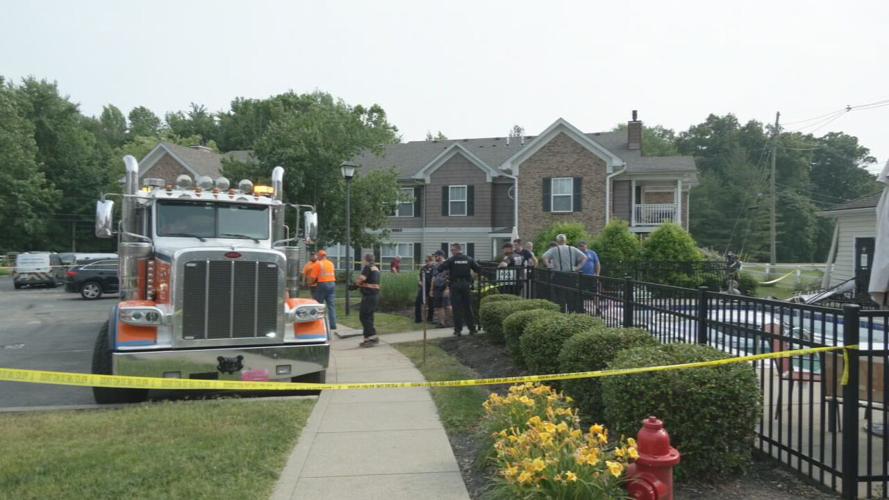 Crews near swimming pool with submerged car on Brook Bend Way