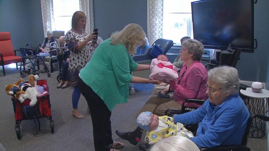 Senior with baby doll brought by Pearl's Memory Babies