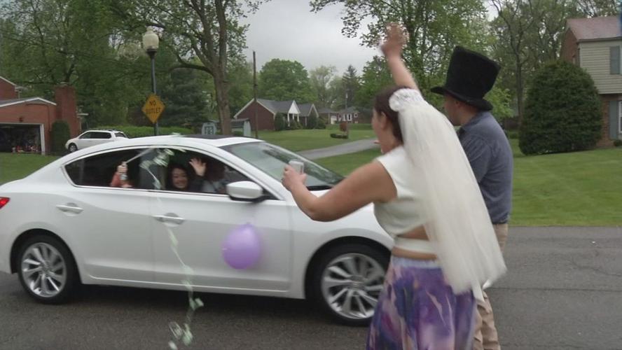 Katie and Ryan Loveall wave at wedding parade