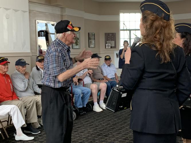 A World War II veteran enjoys the company of Ladies of Liberty, a female singing group