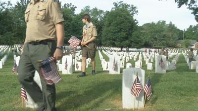 Boy Scouts put flags on headstones for Memorial Day