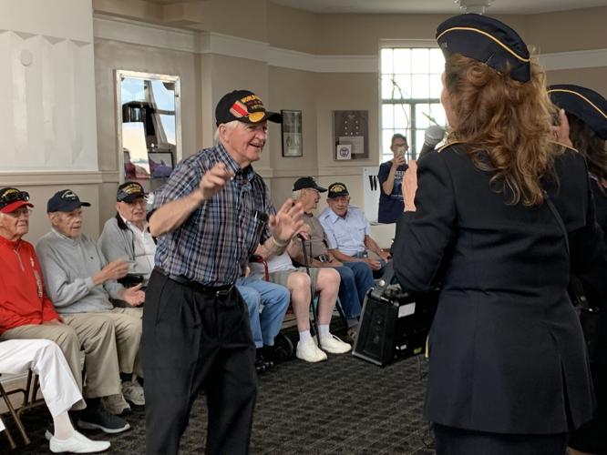 A World War II veteran enjoys the company of Ladies of Liberty, a female singing group