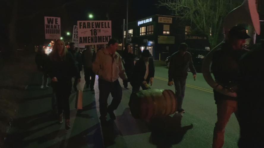 People roll bourbon barrels during Repeal celebration in Louisville