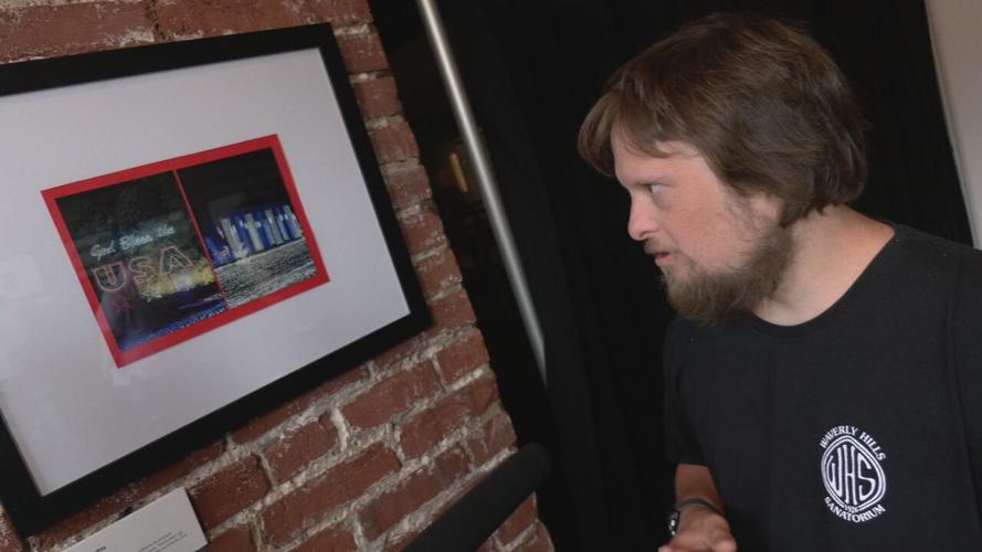 Artist Corey Morgan reviews his artwork at a Frazier History Museum exhibit