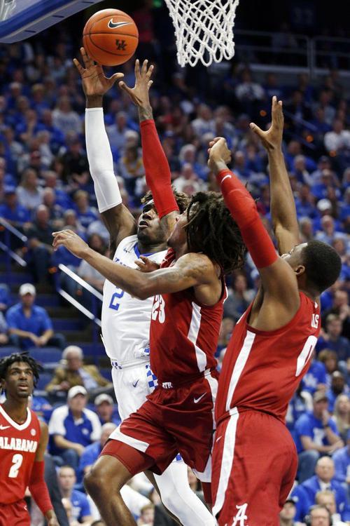 Kentucky's Kahlil Whitney, left, shoots while pressured by Alabama's John Petty Jr. and Javian Davis