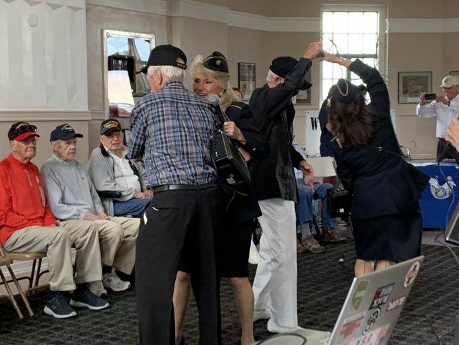 World War II veterans enjoy the company of Ladies of Liberty, a female singing group