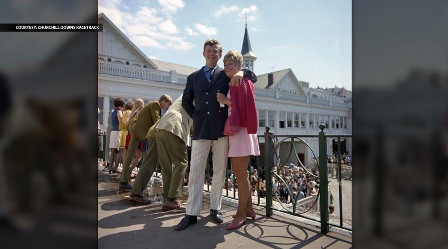 1970_Derby_595 – “Unidentified couple posing for a photographer on the walkway above the paddock area.”