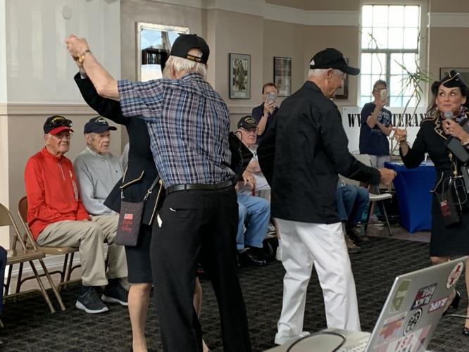 World War II veterans enjoy the company of Ladies of Liberty, a female singing group