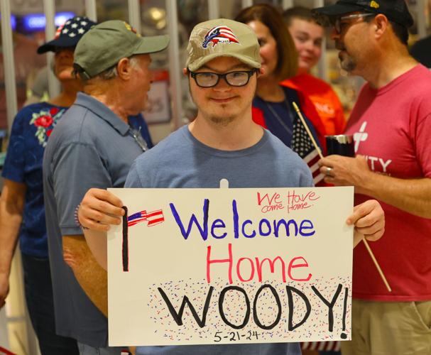 Welcome Home Woody sign is held up at Honor Flight Return Home.JPG