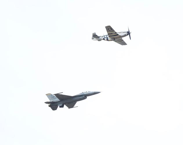 Old World War II plane and new plane fly.JPG