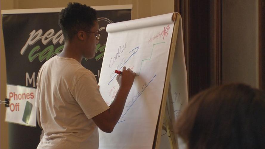 Writing on board at PeaceCasters summer camp