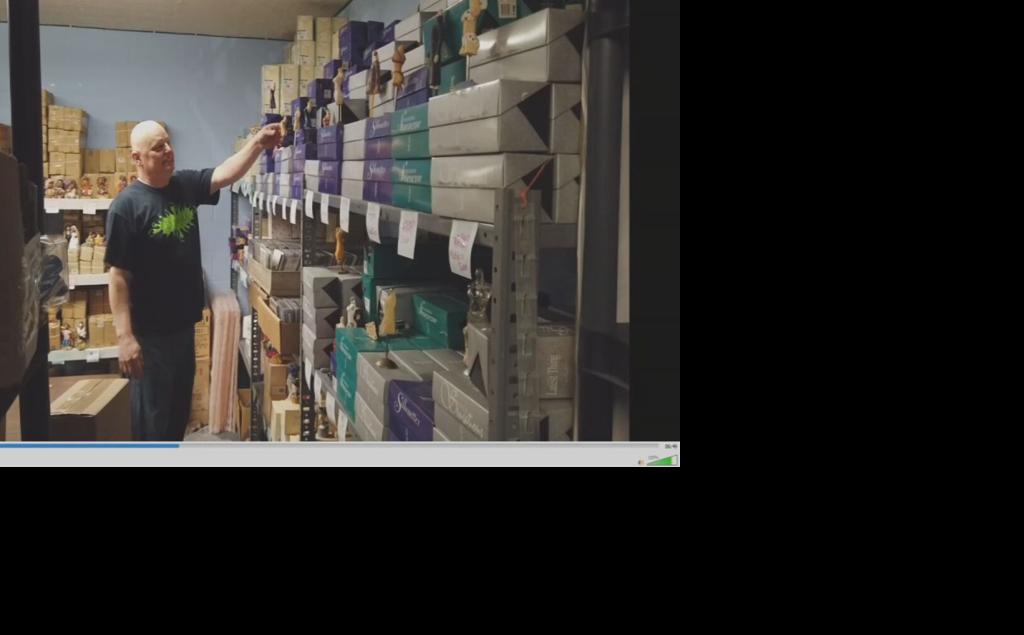 Curtis holds up figurines inside home