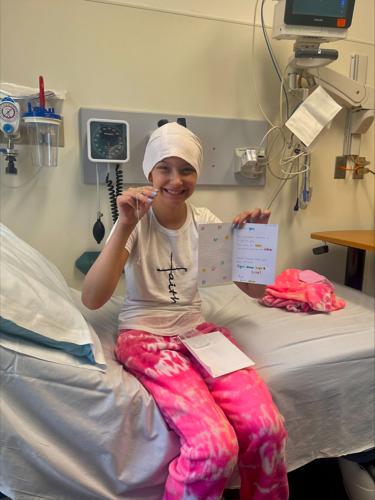 Alexis Bibb holds up card and gift from well-wishers