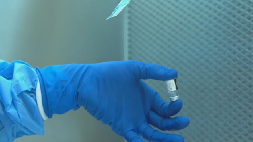 COVID vaccine in gloved hand