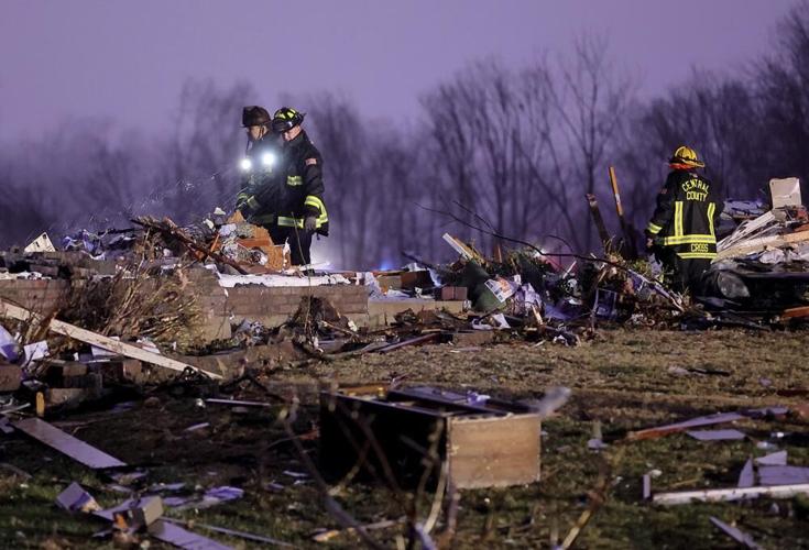 Firefighters search a debris field that came from a house that was ripped off its foundation and trees were cut.jpeg