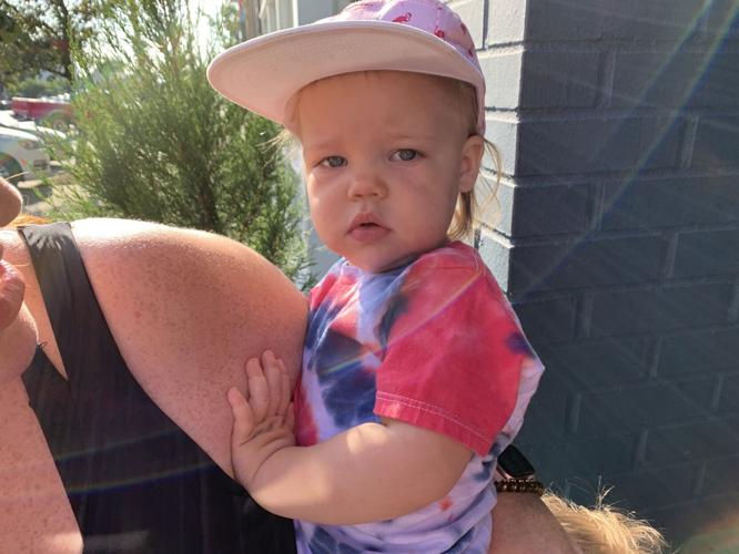 Woman holds child in Louisville's NuLu neighborhood