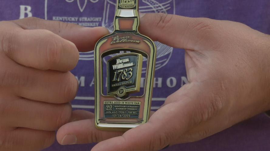 Russell Deacon holds Urban Bourbon half marathon medal