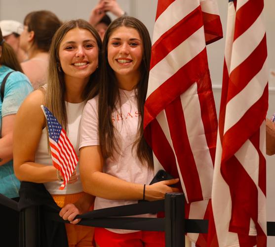 Two girls hold American flags during Honor Flight Return home.JPG