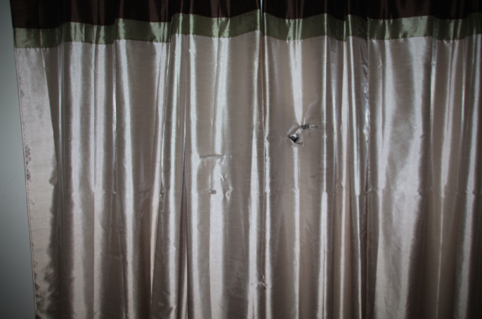 Bullet holes in Breonna Taylor's window curtains