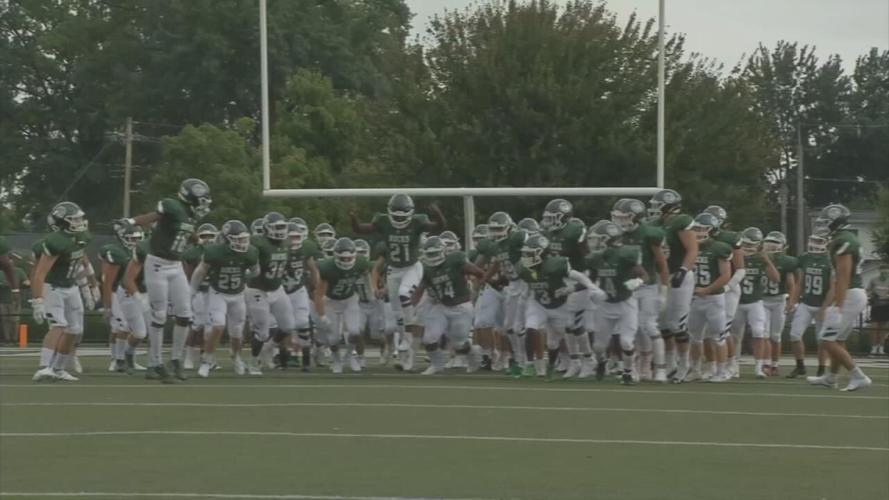 Trinity football team runs onto the field