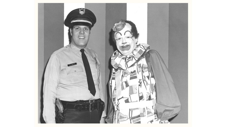 Presto the Magic Clown poses with law enforcement officer