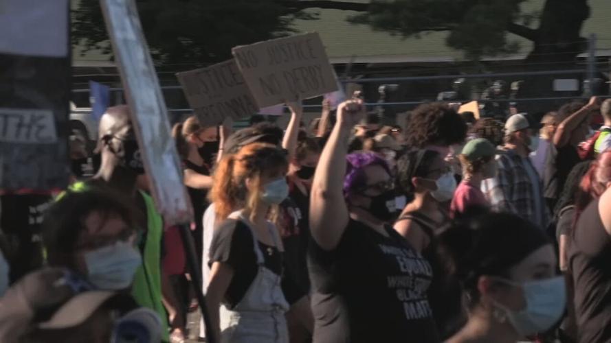 Protesters march past Churchill Downs during Derby