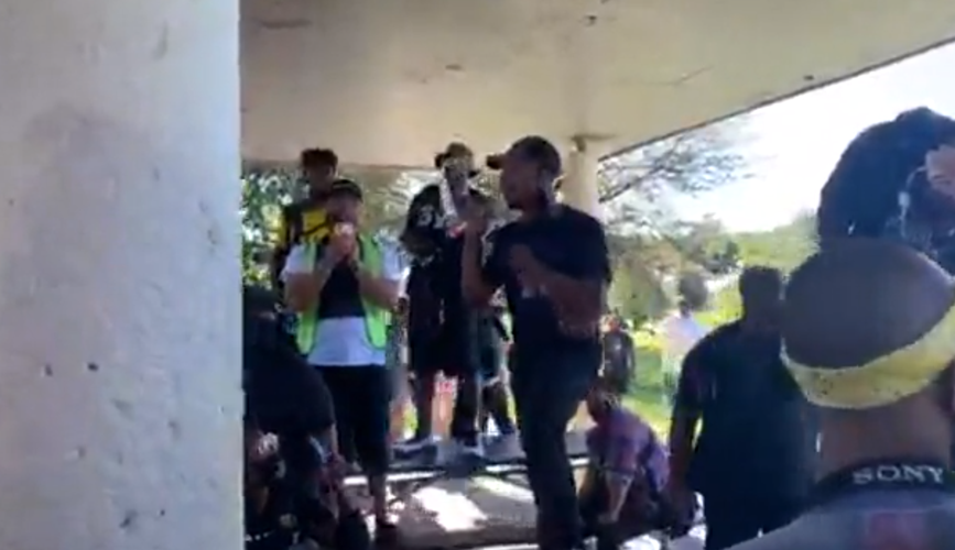 A speaker addresses Louisville protesters at South Central Park on Derby day