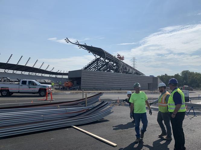 Crews shape the panels for the roof at Lynn Family Stadium