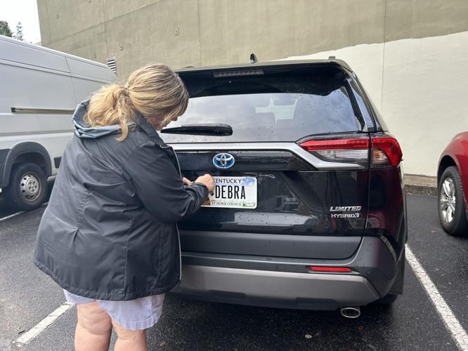 Debra Humphrey gets personalized license plate put on her new car Sept. 24, 2024. (WDRB News image)