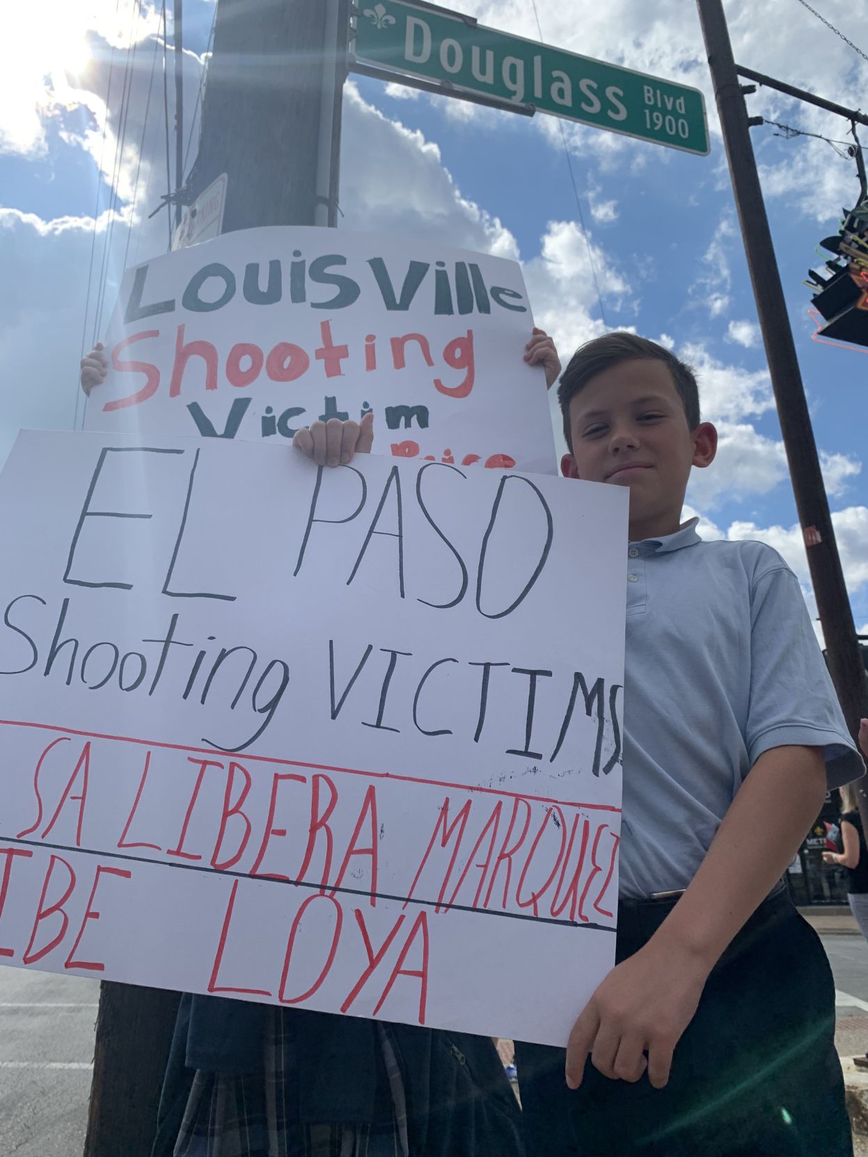 Students hold sings at Saint Francis of Assisi anti-violence walk