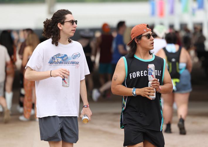 Two people walk through crowds at Forecastle.JPG