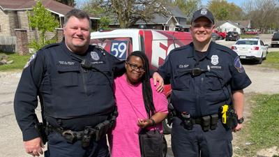 Angela Hughley (center), flanked by IMPD Patrolman Skip Copeland (left) and Officer Jason Niewedde (right)