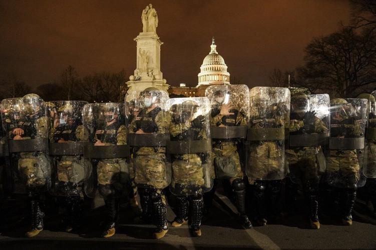 District of Columbia National Guard stand outside the Capitol, Wednesday night, Jan. 6, 2021