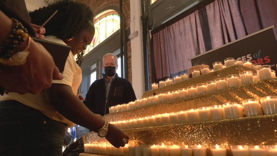 Lighting candle at gun violence memorial 2-19-22