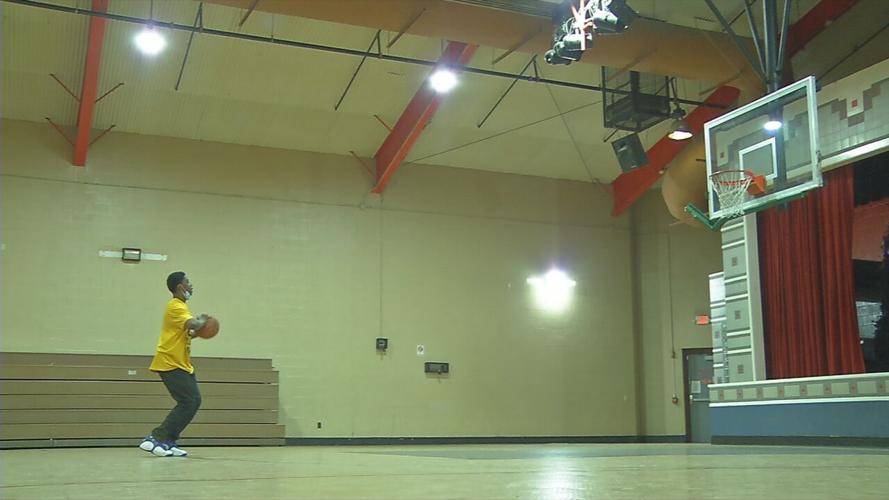 A teen plays basketball at the Parkhill Community Center