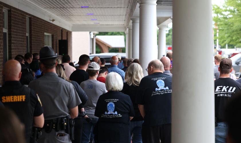 People stand during Jason Ellis memorial.JPG