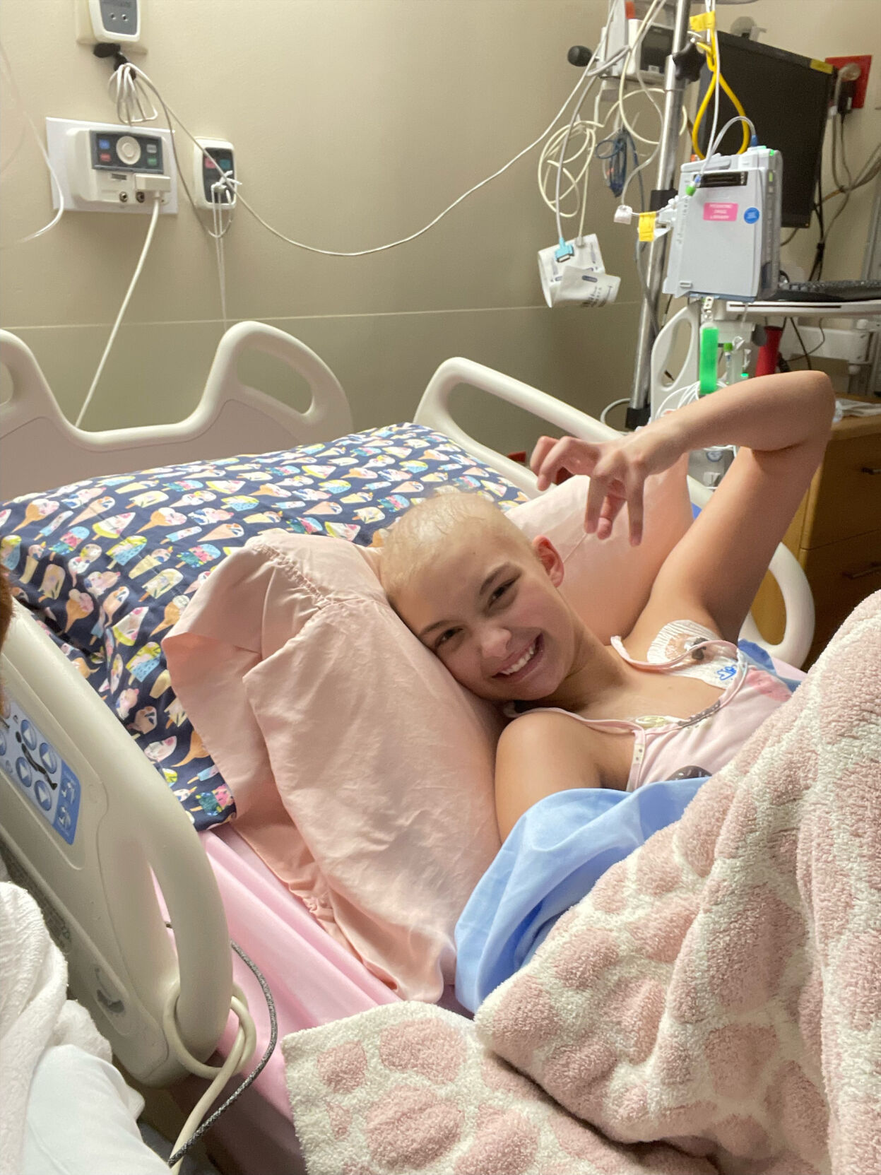 Alexis Bibb smiles and gestures from hospital bed