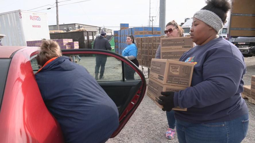 Volunteers load boxes of Girl Scout Cookies outside warehouse in Louisville