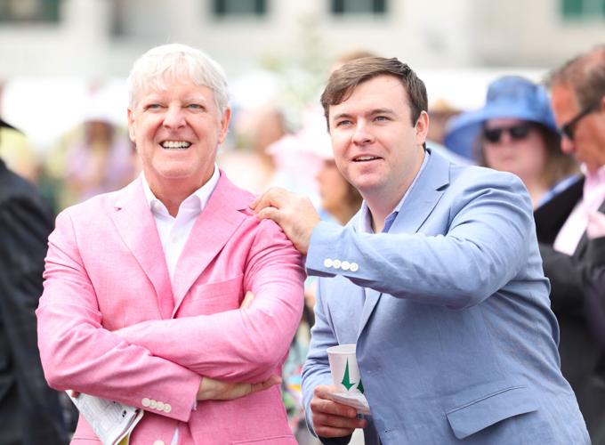 Two men watch horse race.JPG