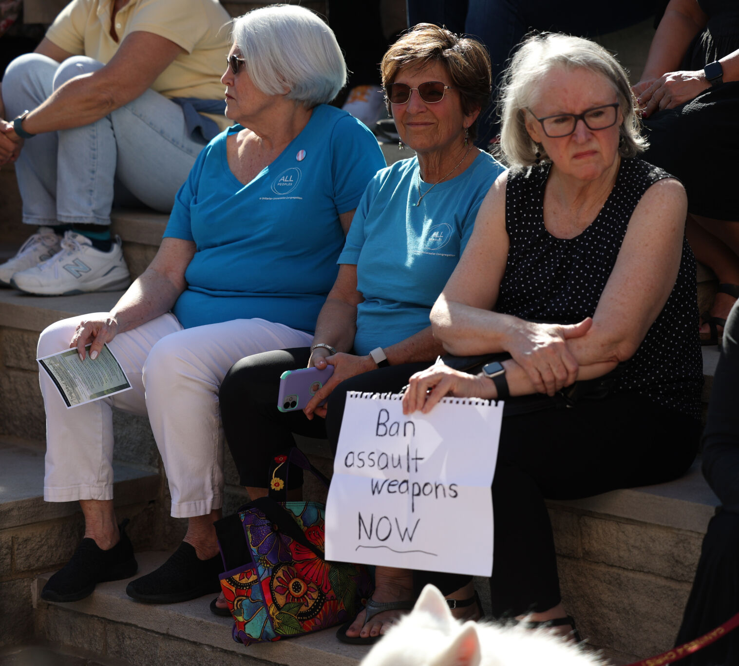 Woman holds sign against assault rifles.JPG