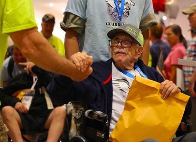 Veteran and volunteer embrace during Honor Flight Return Home.JPG