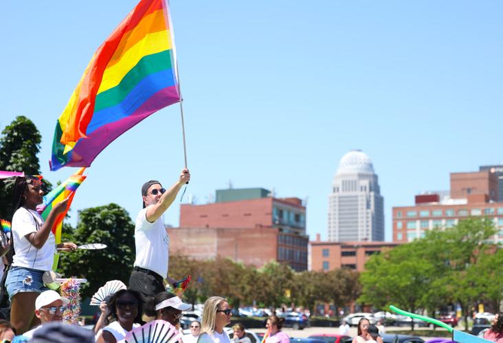 Flag waves with skyline at Kentuckiana Pride Parade